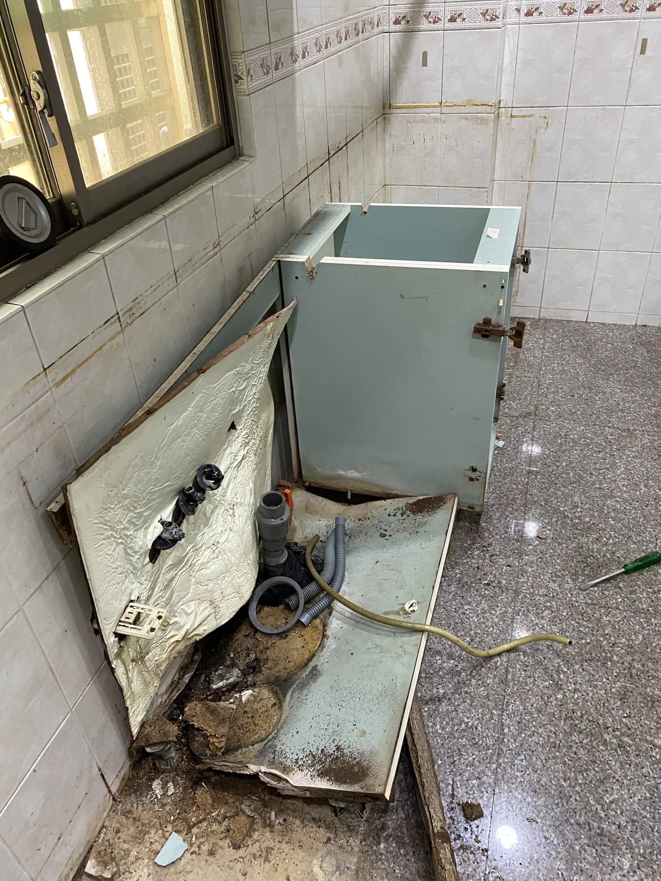 舊廚櫃移除後露出的磁磚牆面、地坪與給排水位置