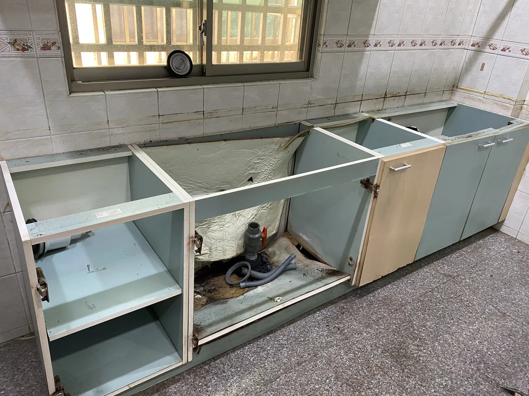 施工人員拆除窗下的舊廚房地櫃