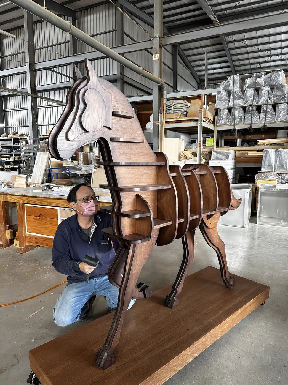 愛森工廠內以人物對照大型木製展示馬比例