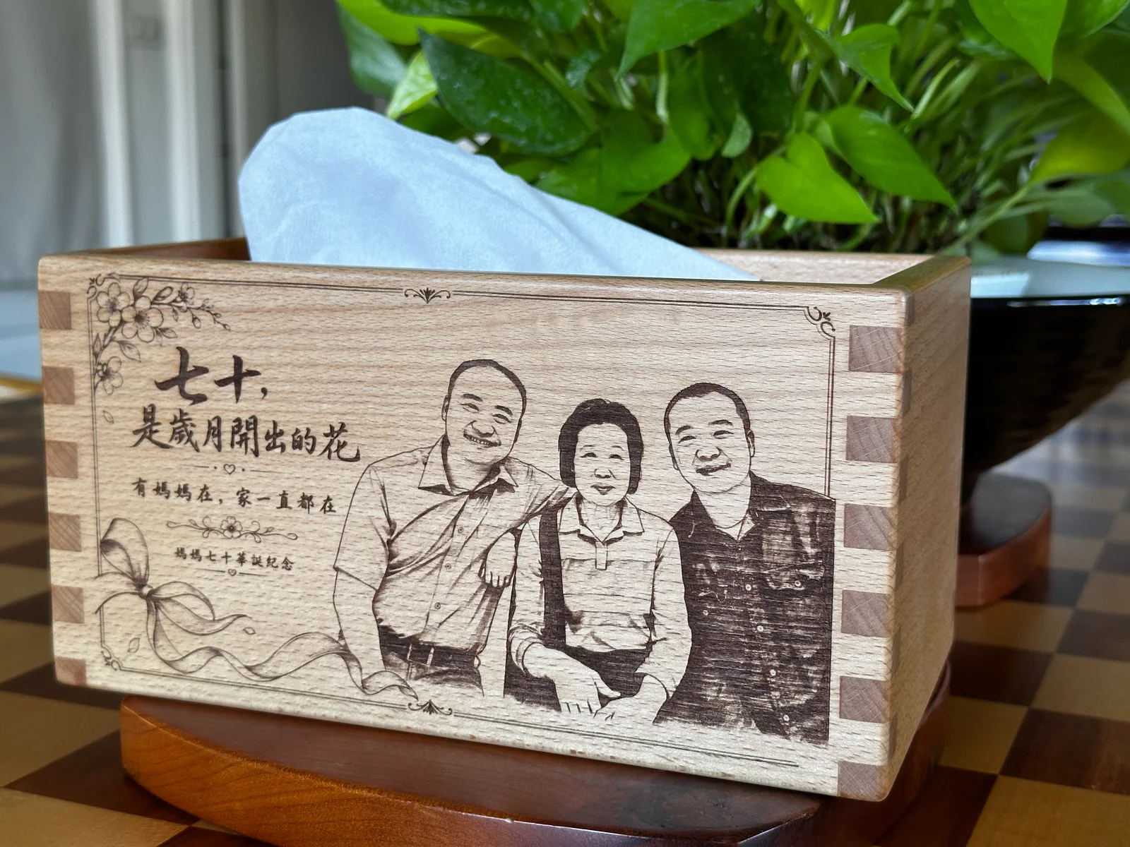 媽媽七十歲生日紀念雷雕面紙盒，刻有人像、祝福文字與木作榫接細節