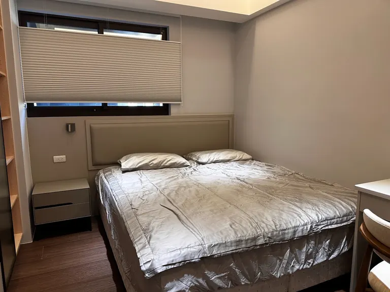 窗下床頭　壁板及框線配合窗下空間配置。兩張照片為不同位置的完工實景，不作前後對照；軟包、燈具、水電與其他家具不據此列入愛森施作範圍。