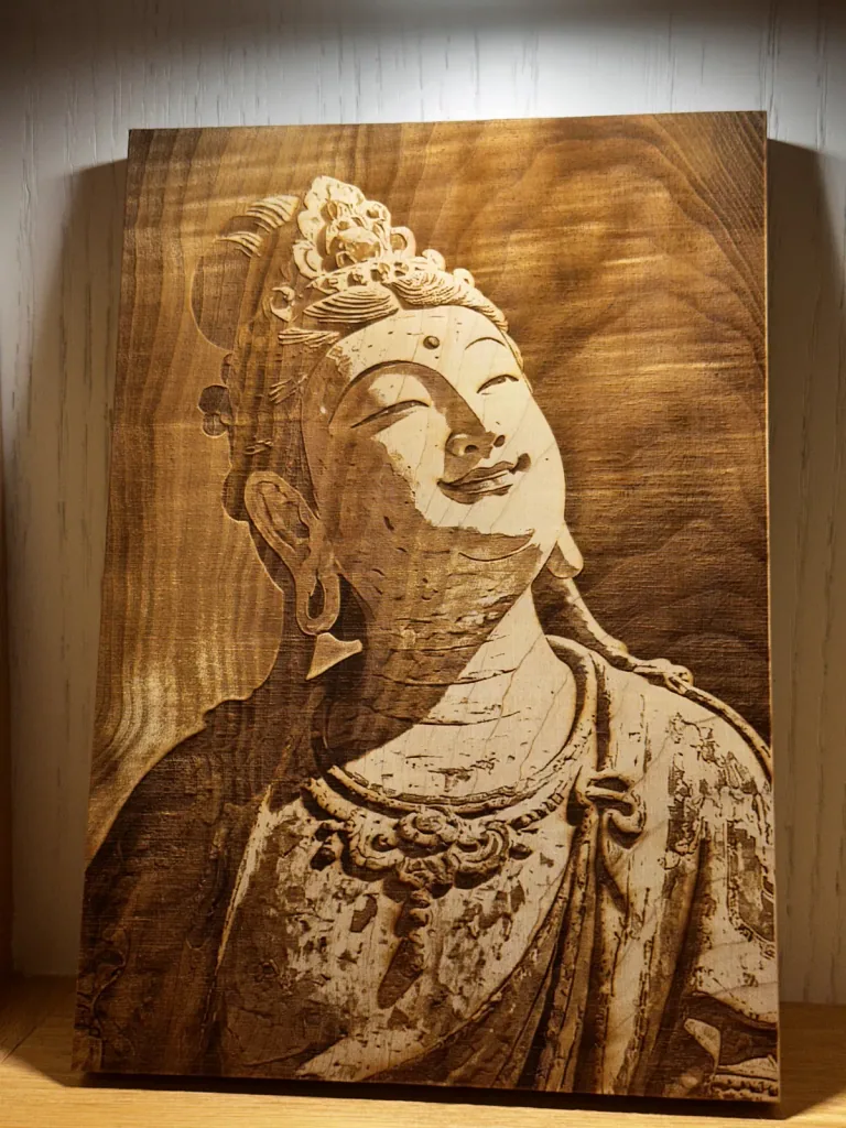 佛像側臉與衣飾細節雕刻在木板上的作品