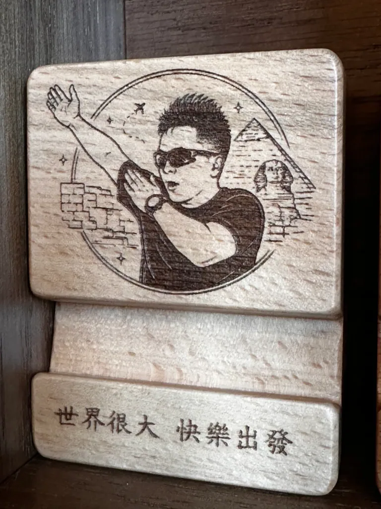 人物肖像與紀念文字刻在木質手機架上的完成作品