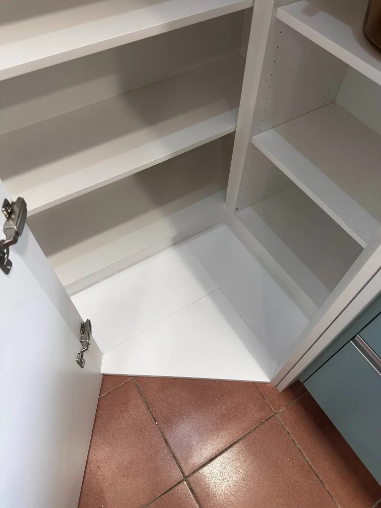 回應屋主對櫃底縫隙的顧慮，在轉角高櫃內增加底板；門片仍保留正常開啟所需的活動間隙。