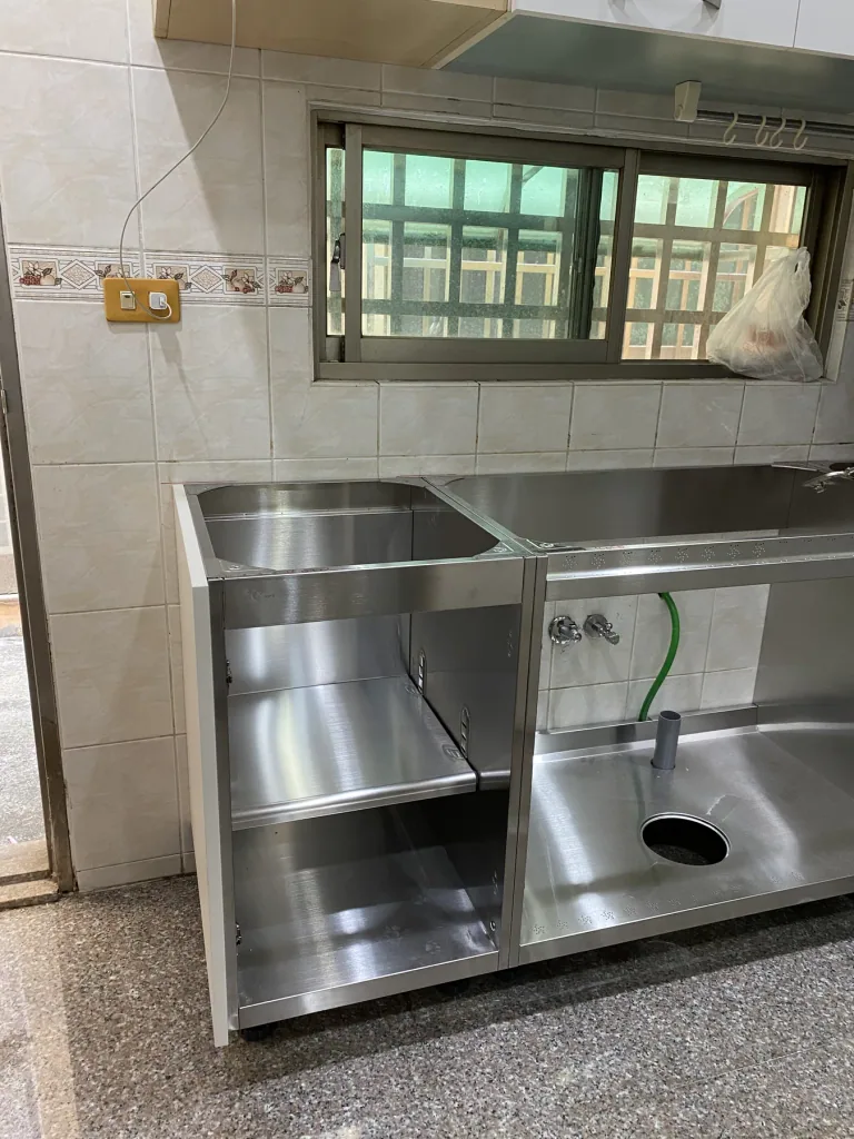 窗下完成定位的不鏽鋼檯面、水槽與水龍頭預留孔