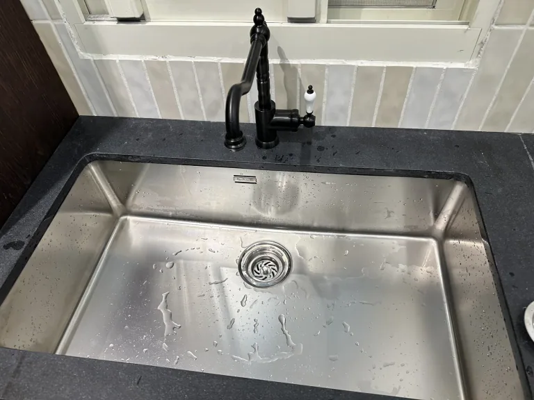 水槽與檯面的銜接 黑色檯面、不鏽鋼水槽與黑色水龍頭配置