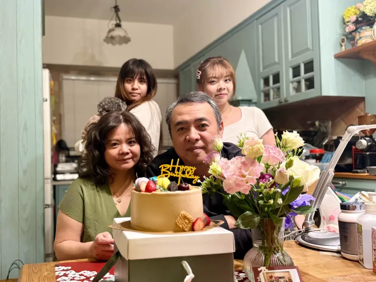 屋主一家人在埔里實木廚房前與生日蛋糕及花束合影